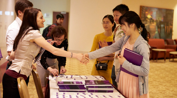Two students shaking hands at an event